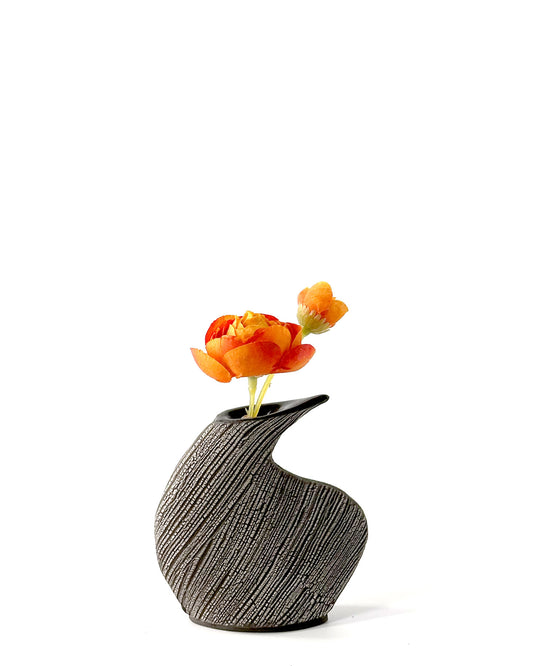 Black textured vase with orange flowers on a white background